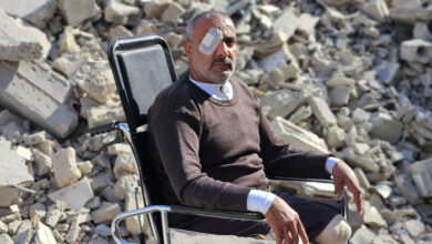 صورة غزاوي أقعدته وحشية القصف يستذكر أولاده الشهداء أمام ركام منزله