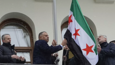 صورة إنزال علم النظام من سفارة سوريا في موسكو ورفع علم الثورة بدلًا منه